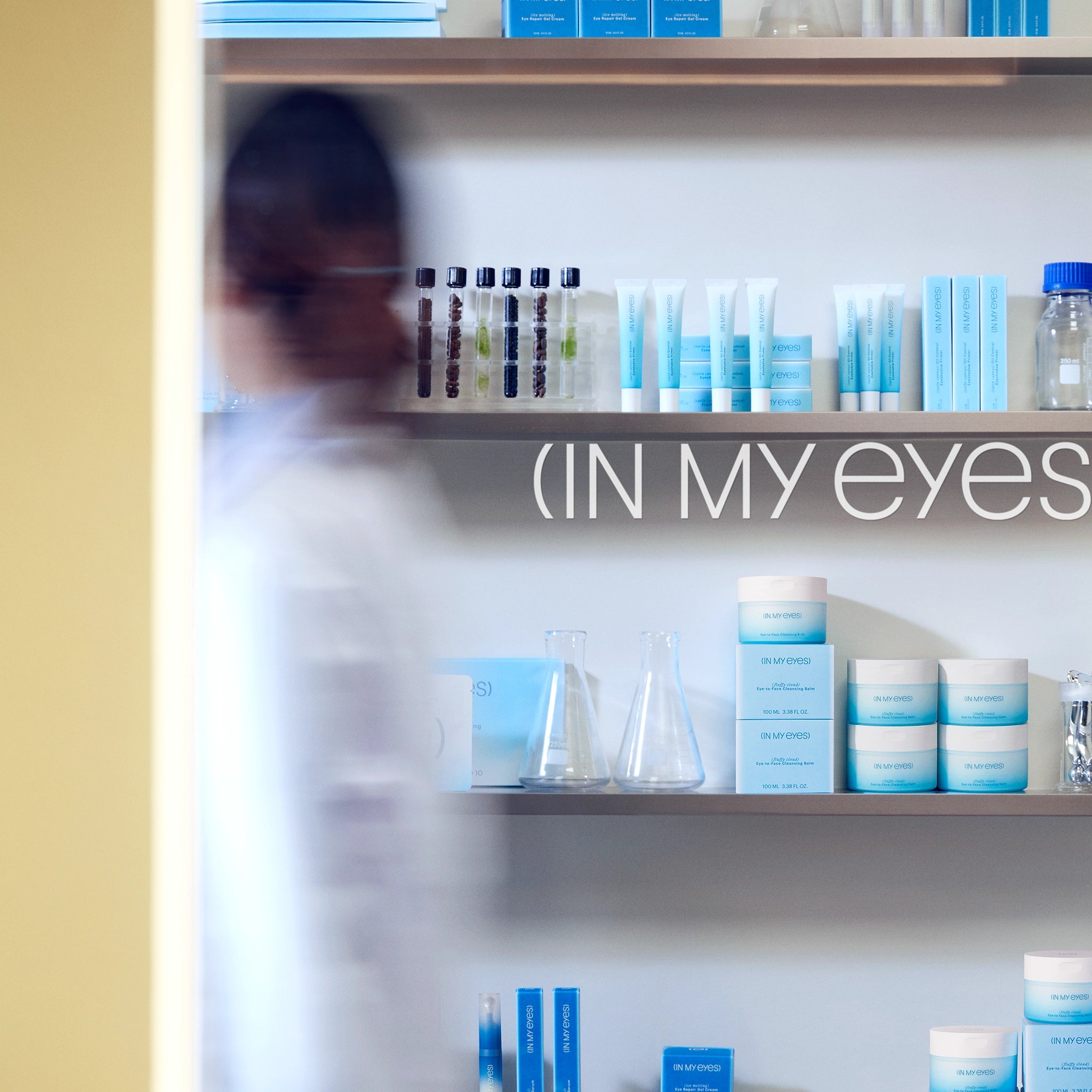 Shelf with skincare products and 'IN MY EYES' branding in a clinical setting.