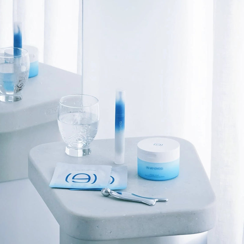 Cosmetic products on a white surface with a blurred background, In My Eyes