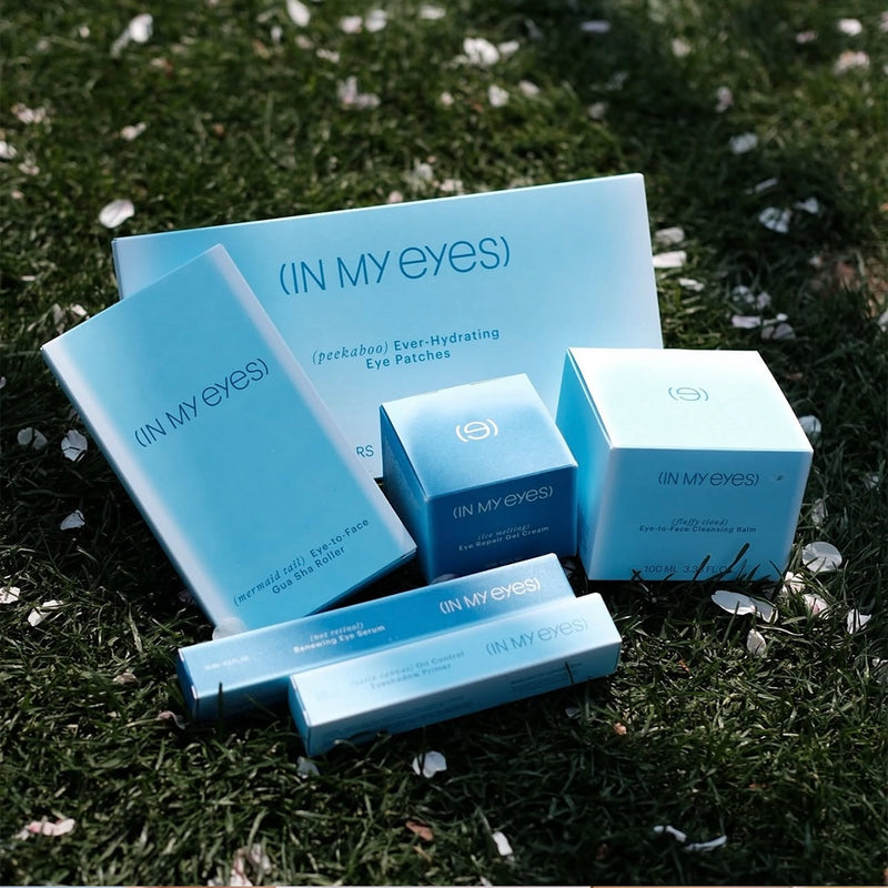 Cosmetic products with 'IN MY EYES' branding on a grassy background