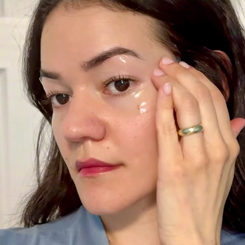Woman applying cream to her face with a neutral background, Using In My Eyes Eye Patches, Eye Mask